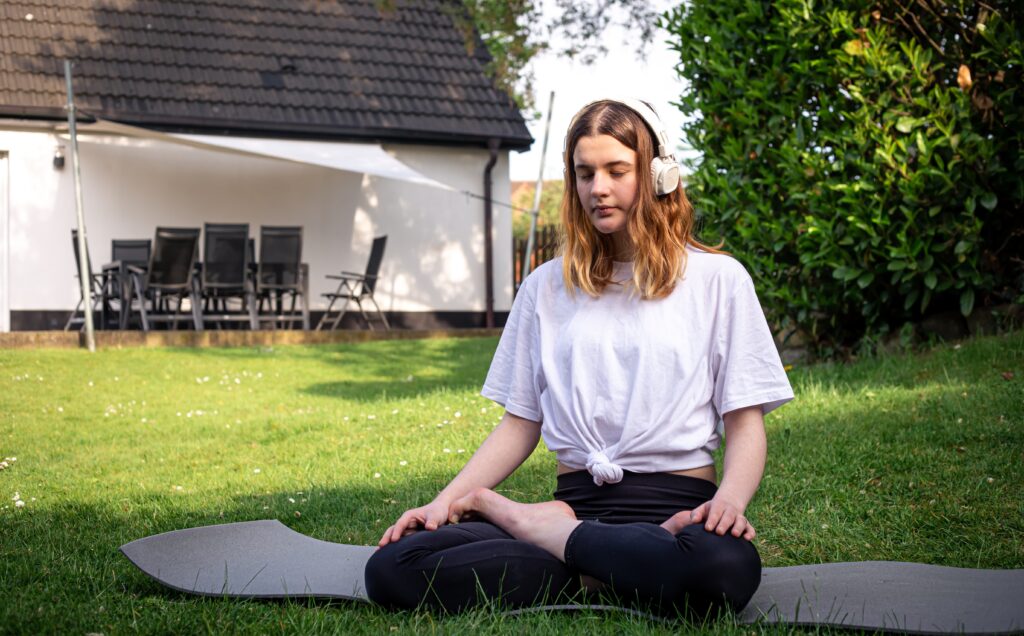 young woman practices yoga nature grass yard 1
