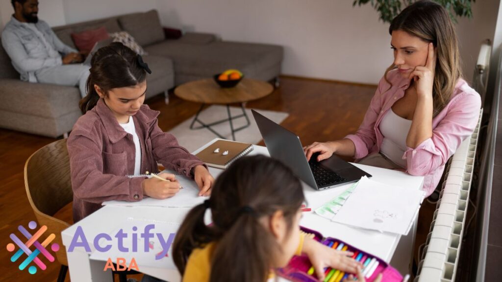 A group of children, including those with autism, complete tasks in a therapy room while their instructor writes a lesson plan, combining learning and individualized support.