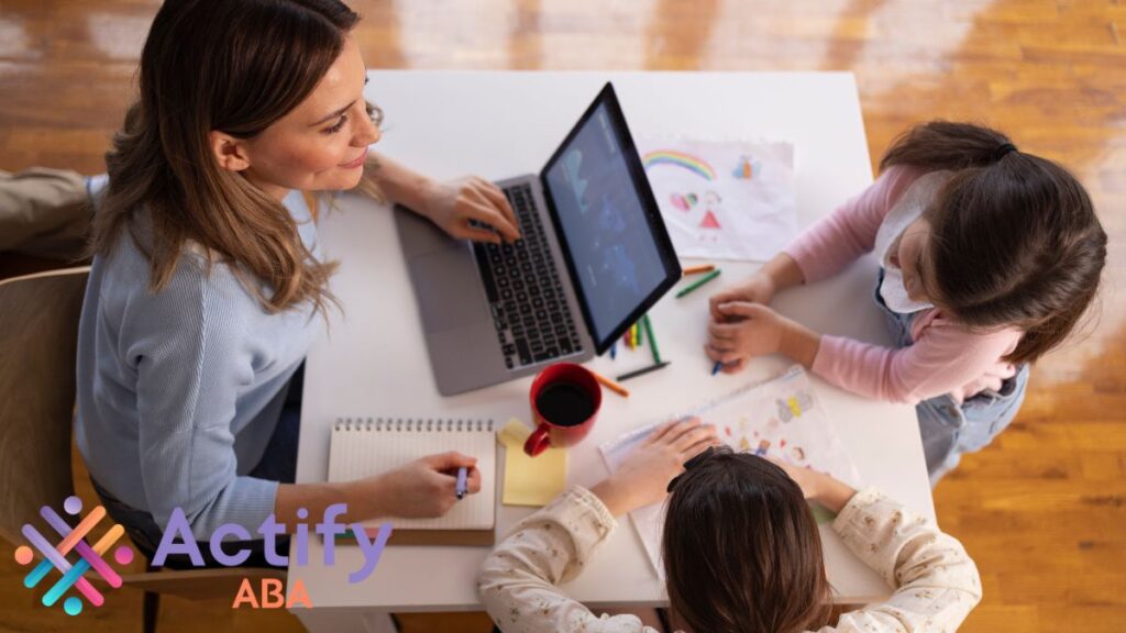 A female teacher guides a small group of students, including children with autism, through interactive play and instruction to support learning and social skills.