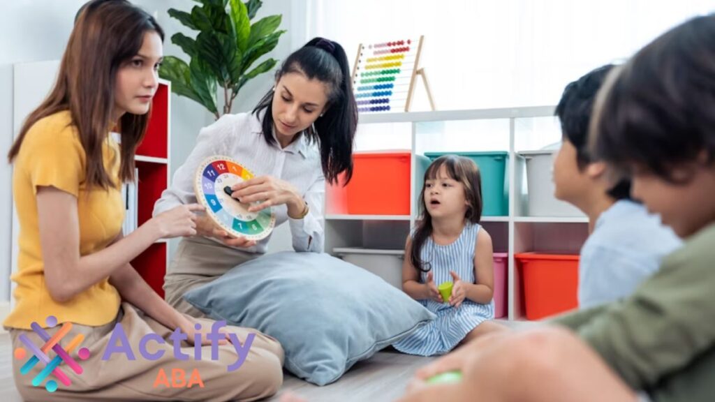 How many hours of ABA therapy is needed? A teacher lifts a toy clock while students sit on the floor, learning focus and social skills through play.