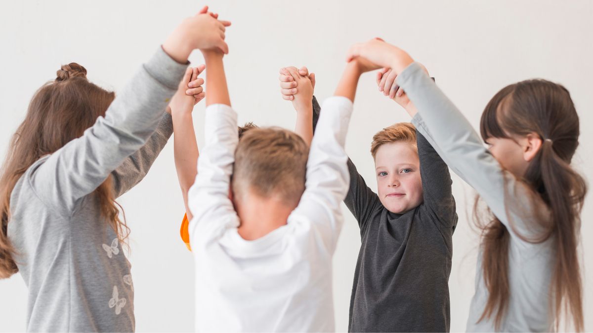 A group of children huddle in a circle with their hands raised and interconnected, symbolizing their shared advocacy for Everyday Is Autism Awareness Day.