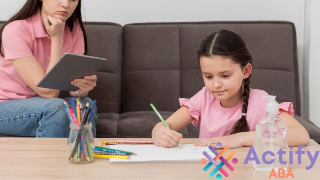 A young girl completes a writing task at a coffee table while a therapist observes, illustrating ASD support.