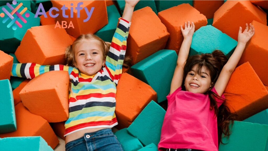 Proprioception autism: a pair of children settle happily in an obstacle course room with soft oversized blocks.
