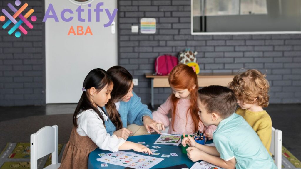 A group of children work together on a project around a round table, heads bent in concentration, highlighting collaboration and focus.