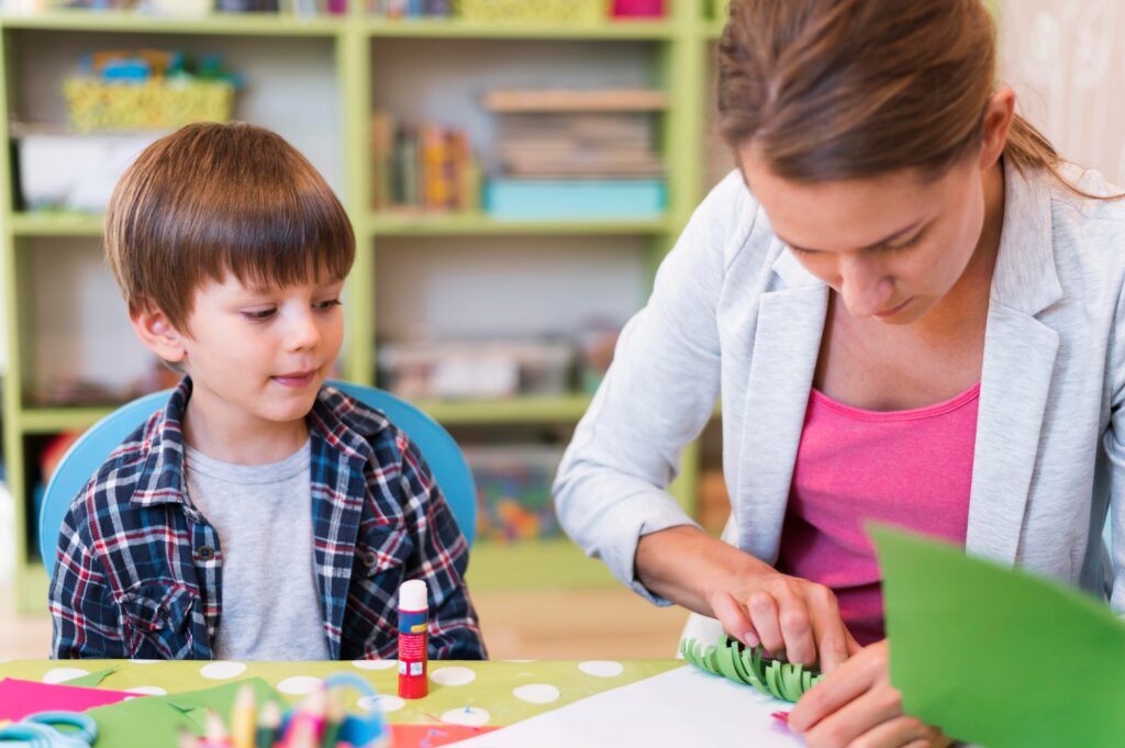 medium shot teacher helping little boy 1